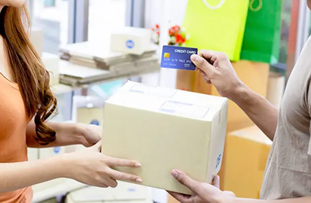 箱を手渡しながらクレジットカードで支払う様子