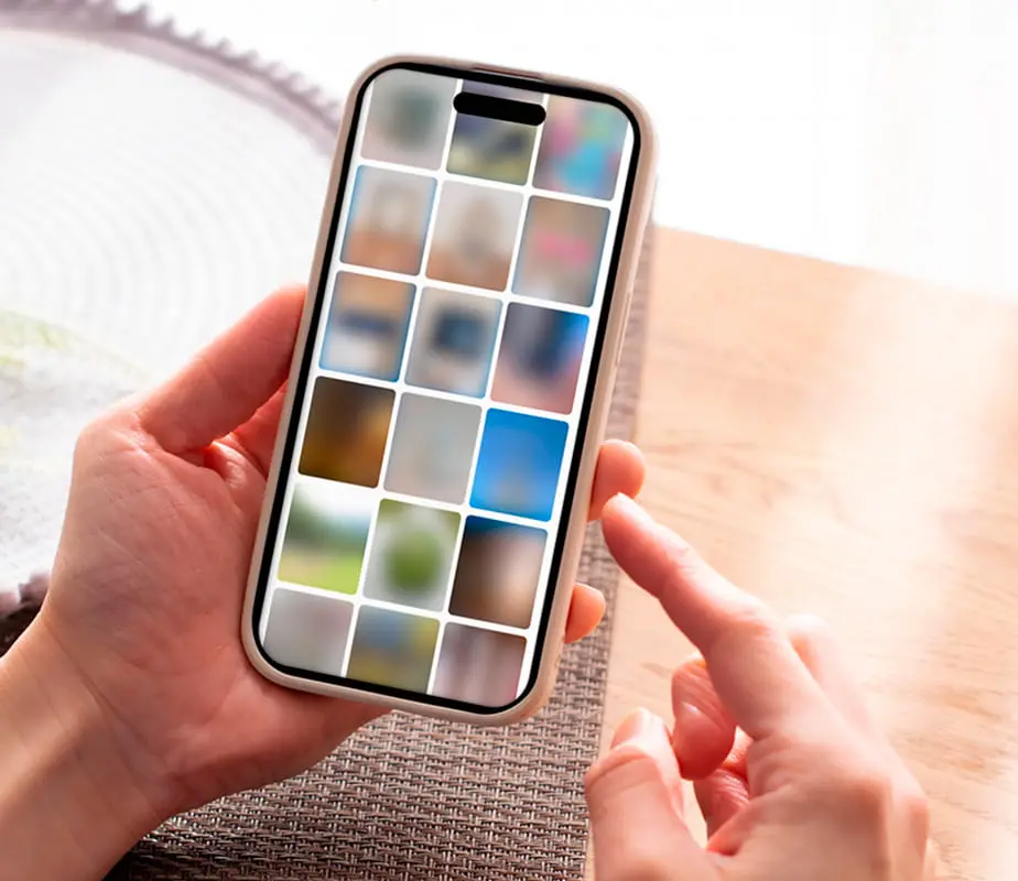 スマートフォンの画面に並んだ複数の画像を指で操作している様子